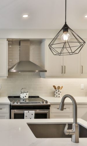 kitchen with white stone countertops with under mount sink white cabinet black accent and polkadot accessories