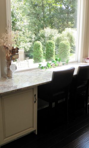 Pentagon stone countertop on white cabinet in front of window side view